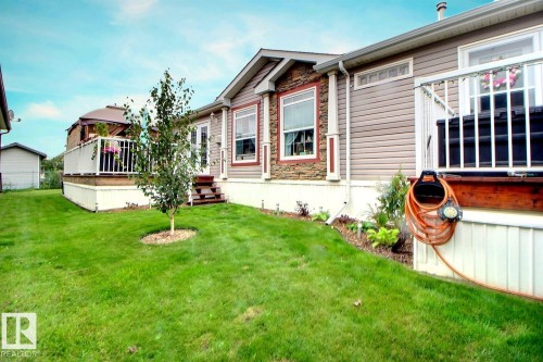 Exterior featuring siding, stone accents, and multiple windows - 417 Oak Wood Crescent Northwest, Edmonton, AB - Outdoor With Deck Patio Veranda