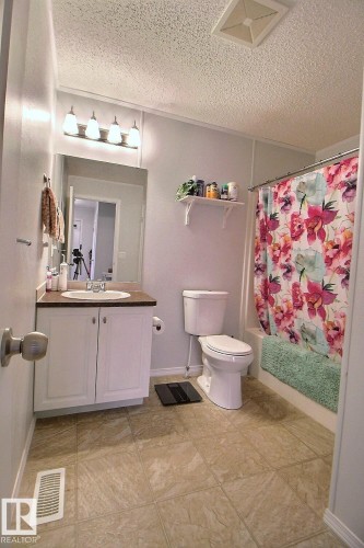 Bathroom with a white vanity, integrated sink, and wall-mounted lighting fixture - 417 Oak Wood Crescent Northwest, Edmonton, AB - Indoor Photo Showing Bathroom