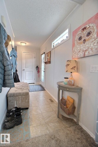 Hallway featuring mixed flooring, a white paneled door, and an overhead transom window - 417 Oak Wood Crescent Northwest, Edmonton, AB - Indoor Photo Showing Other Room
