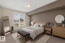 Window with horizontal blinds, light-toned wall finishes, and a flush-mount ceiling light fixture - #205 6315 135 Av Nw, Edmonton, AB  - Indoor Photo Showing Bedroom 