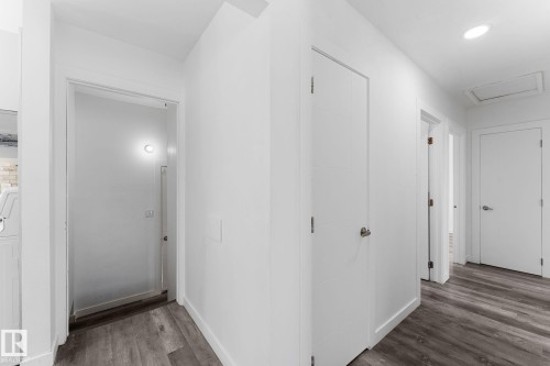 Light wood-finish flooring with white walls and trim throughout - 7823 136 Avenue Nw, Edmonton, AB - Indoor Photo Showing Other Room