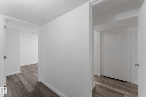 Wood-finish flooring throughout, white walls, and white trim - 7823 136 Avenue Nw, Edmonton, AB - Indoor Photo Showing Other Room