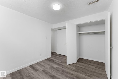 Recessed closet with built-in shelving and hanging rod - 7823 136 Avenue Nw, Edmonton, AB - Indoor Photo Showing Other Room