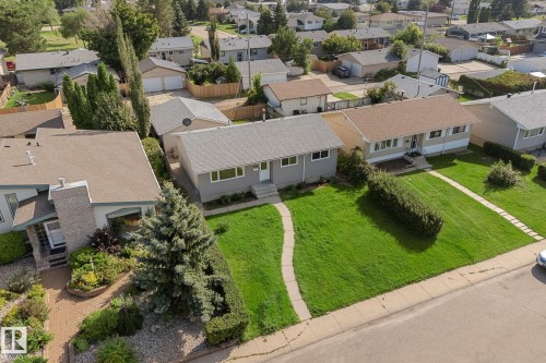 Well-maintained property with a spacious front lawn, mature trees, and a paved walkway - 7823 136 Avenue Nw, Edmonton, AB - Outdoor