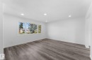 Spacious room featuring wood-finish flooring, recessed lighting, and a large multi-pane window - 7823 136 Avenue Nw, Edmonton, AB  - Indoor Photo Showing Other Room 