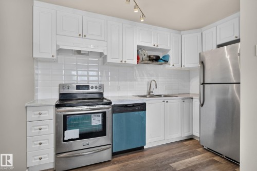 White shaker-style cabinetry, stainless steel appliances, wood-finish flooring, white subway tile backsplash, and track lighting - 17775 95 Street Nw, Edmonton, AB 