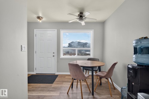 White paneled door, wood-finish flooring, ceiling fan, and prominent window - 17775 95 Street Nw, Edmonton, AB 