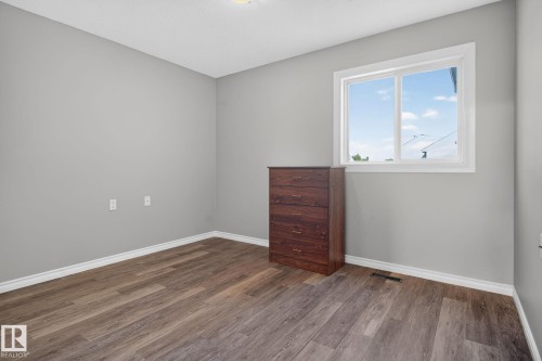 Neutral gray walls with white trim, wood-finish flooring, and a white-framed window - 17775 95 Street Nw, Edmonton, AB 