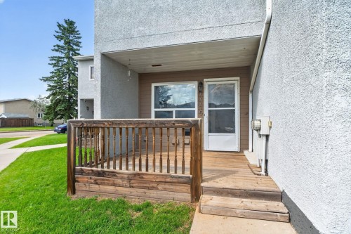 Wood-tone deck with railing, covered porch, and exterior entry door - 17775 95 Street Nw, Edmonton, AB 