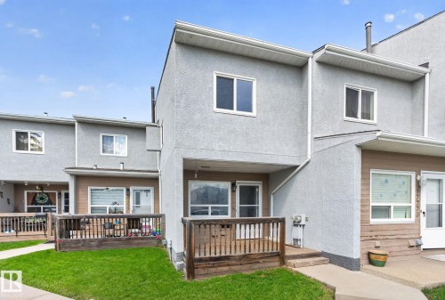 Stucco exterior with multiple windows, wooden deck, and concrete walkway - 17775 95 Street Nw, Edmonton, AB 