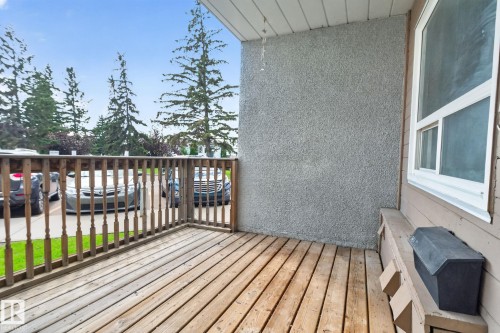 Wooden deck with spindle railing, stucco exterior wall, and white-framed window - 17775 95 Street Nw, Edmonton, AB 