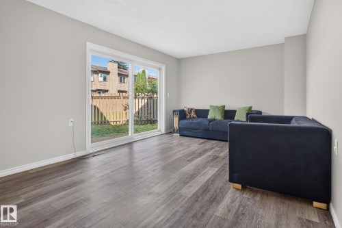 Wood-finish flooring throughout, sliding glass door leading to the exterior, and light-toned walls - 17775 95 Street Nw, Edmonton, AB 