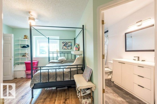 Wood-finish flooring, ceiling fan with integrated lighting, built-in shelving, white paneled door, and a window providing natural light - 4705 43 Street, Beaumont, AB 