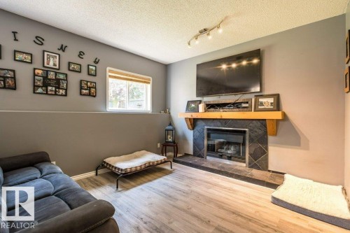 Fireplace with a stone surround and wood mantel - 4705 43 Street, Beaumont, AB 