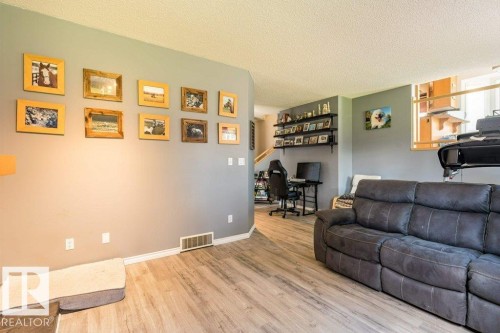 Wood-finish flooring throughout, complemented by a muted wall color - 4705 43 Street, Beaumont, AB 