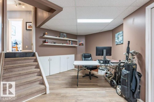 Wood-finish flooring, built-in white cabinetry, white floating shelves, recessed lighting, and a drop ceiling - 4705 43 Street, Beaumont, AB 