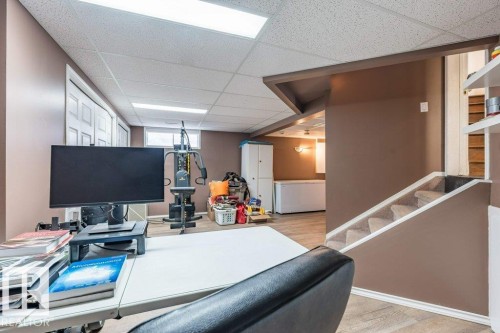 Carpeted stairs leading to a lower level with wood-finish flooring, drop ceiling, and recessed lighting - 4705 43 Street, Beaumont, AB 