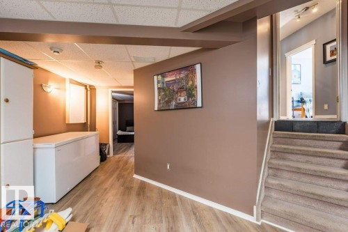 Finished lower level space with wood-finish flooring, drop ceiling, and recessed lighting - 4705 43 Street, Beaumont, AB 