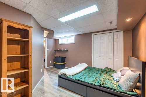 Recessed ceiling lighting, drop ceiling, wood-finish flooring, bi-fold closet doors, and a window for natural light - 4705 43 Street, Beaumont, AB 