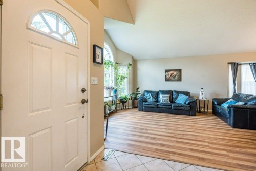 Entry with a decorative transom window, tile flooring, wood-finish flooring, and arched windows - 4705 43 Street, Beaumont, AB 