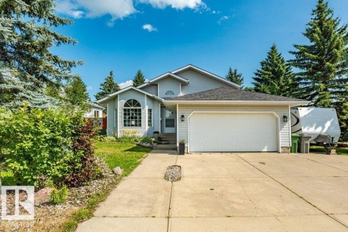 Light-colored siding exterior with an attached two-car garage - 4705 43 Street, Beaumont, AB 