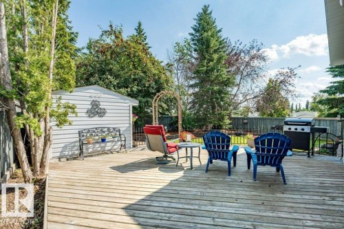 Expansive wood deck with fenced perimeter, large storage shed, and mature trees - 4705 43 Street, Beaumont, AB 
