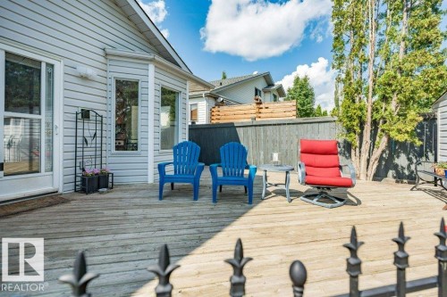 Expansive wooden deck with a sliding glass patio door, bay window, and privacy fencing - 4705 43 Street, Beaumont, AB 