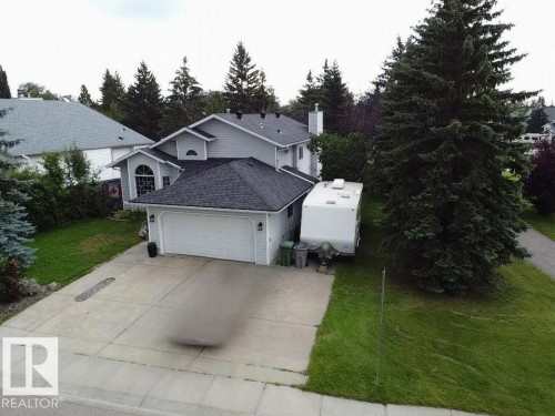 Two-story residence with light gray siding, an attached two-car garage, and a concrete driveway - 4705 43 Street, Beaumont, AB 