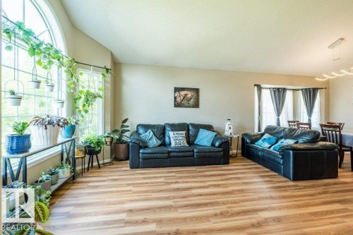 Wood-finish flooring throughout, vaulted ceiling, and an arched window - 4705 43 Street, Beaumont, AB 