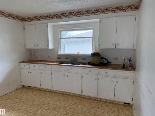 White cabinetry with wood-finish countertops - 5518 51 Street, Vegreville, AB - Indoor Photo Showing Kitchen With Double Sink