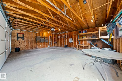 Spacious garage with exposed wood beam ceiling, concrete flooring, and built-in shelving - 17908 92A Street Nw, Edmonton, AB - Indoor Photo Showing Garage