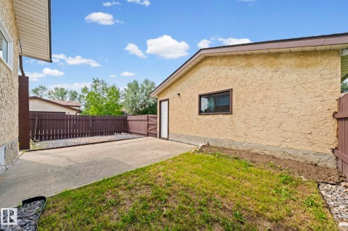 Stucco exterior, fenced yard, concrete patio, exterior access door, and window - 17908 92A Street Nw, Edmonton, AB - Outdoor With Exterior