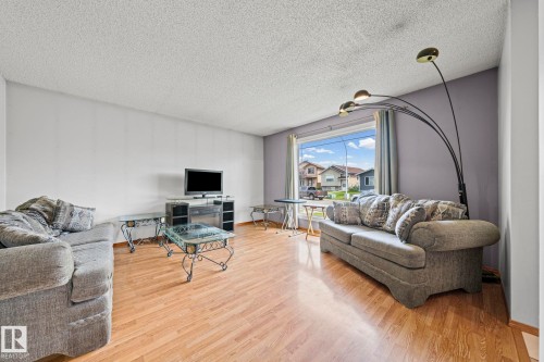 Living area featuring wood-finish flooring, a large picture window, and neutral wall tones - 17908 92A Street Nw, Edmonton, AB - Indoor Photo Showing Living Room