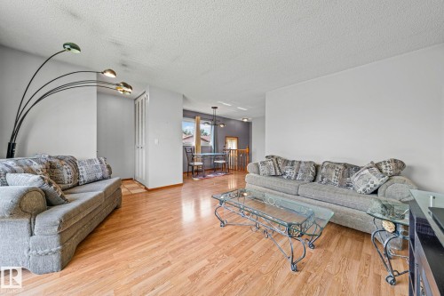 Wood-finish flooring throughout, white walls, and a recessed dining area with a window - 17908 92A Street Nw, Edmonton, AB - Indoor Photo Showing Living Room