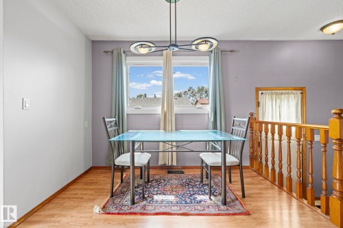 Light wood-finish flooring with white baseboards and a gray accent wall - 17908 92A Street Nw, Edmonton, AB - Indoor Photo Showing Dining Room