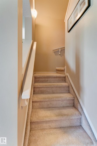 Carpeted staircase with painted handrails and wall-mounted lighting - 6218 1A Avenue Sw, Edmonton, AB - Indoor Photo Showing Other Room