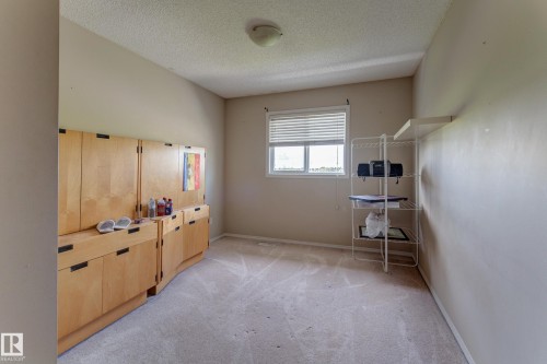 Built-in wood cabinetry with black hardware, neutral wall paint, and a window with horizontal blinds - 6218 1A Avenue Sw, Edmonton, AB - Indoor