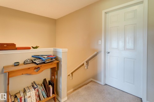 Carpeted flooring, neutral wall paint, white trim, and a white paneled door - 6218 1A Avenue Sw, Edmonton, AB - Indoor Photo Showing Other Room