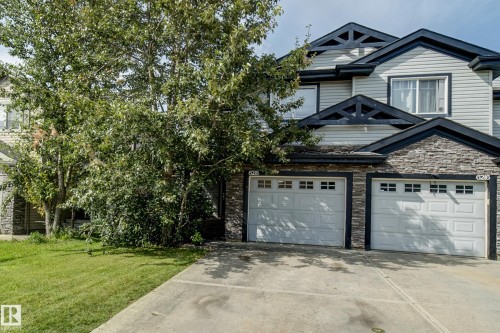 Multi-level exterior with light-colored siding, stone-finish accents, and dark trim - 6218 1A Avenue Sw, Edmonton, AB - Outdoor