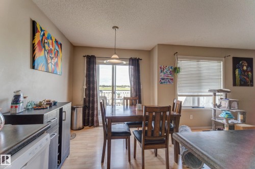 Recessed ceiling lighting, wood-finish flooring, sliding glass door with balcony, window with horizontal blinds, and a built-in buffet cabinet - 6218 1A Avenue Sw, Edmonton, AB - Indoor