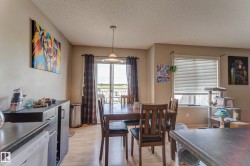 Recessed ceiling lighting, wood-finish flooring, sliding glass door with balcony, window with horizontal blinds, and a built-in buffet cabinet - 