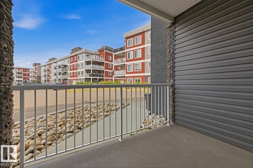 Private balcony with textured flooring, white metal railing, and horizontal siding - #147 1818 Rutherford Rd Sw, Edmonton, AB - Outdoor With Balcony With Exterior