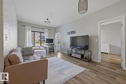 Wood-finish flooring throughout, complemented by a white brick accent wall - 