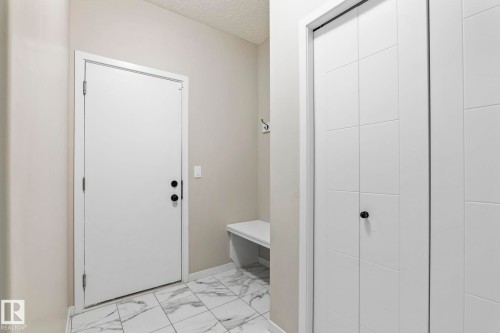 White panel doors, white walls, and white floor tiles with grey veining - 5210 23 Ave Sw, Edmonton, AB - Indoor