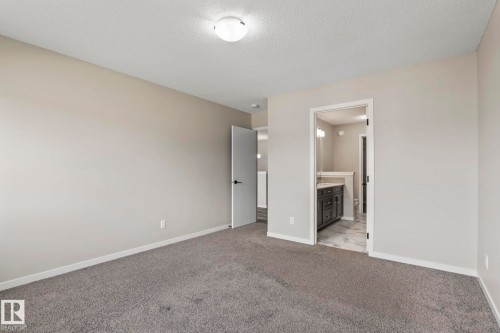 Neutral wall paint, gray carpet, flush-mount ceiling light, white trim, open doorway to bathroom - 5210 23 Ave Sw, Edmonton, AB - Indoor Photo Showing Other Room