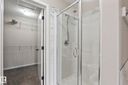 Glass-enclosed shower with a chrome shower head and white subway tile surround - 5210 23 Ave Sw, Edmonton, AB - Indoor Photo Showing Bathroom