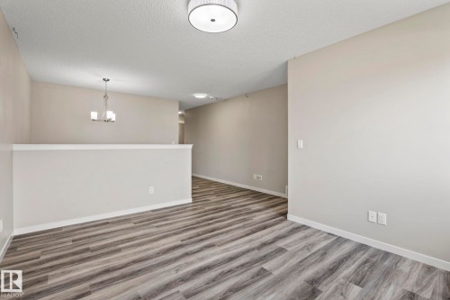 Wood-finish flooring, neutral wall tones, and overhead lighting - 5210 23 Ave Sw, Edmonton, AB - Indoor Photo Showing Other Room