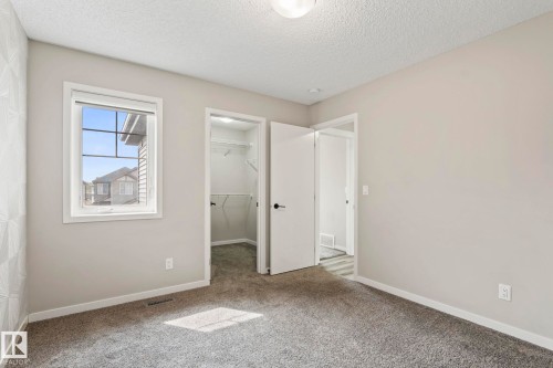 Plush gray carpeting, white trim, recessed lighting, and a walk-in closet with built-in shelving - 5210 23 Ave Sw, Edmonton, AB - Indoor Photo Showing Other Room