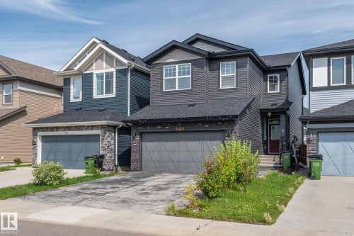 Modern two-story home with a dark gray exterior, attached garage, and stone-clad accents - 5210 23 Ave Sw, Edmonton, AB - Outdoor With Facade