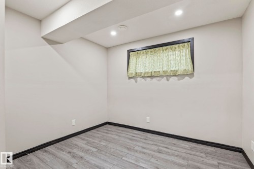 Recessed ceiling lighting, wood-finish flooring, and a window with dark trim - 5210 23 Ave Sw, Edmonton, AB - Indoor Photo Showing Other Room